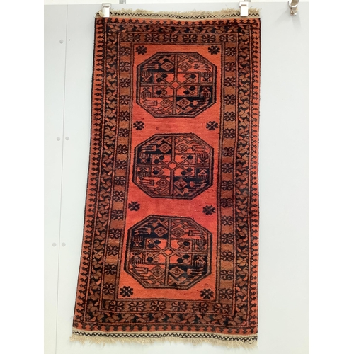 1186 - A pair of Afghan red ground rugs, each 144 x 75cm. Condition - fair