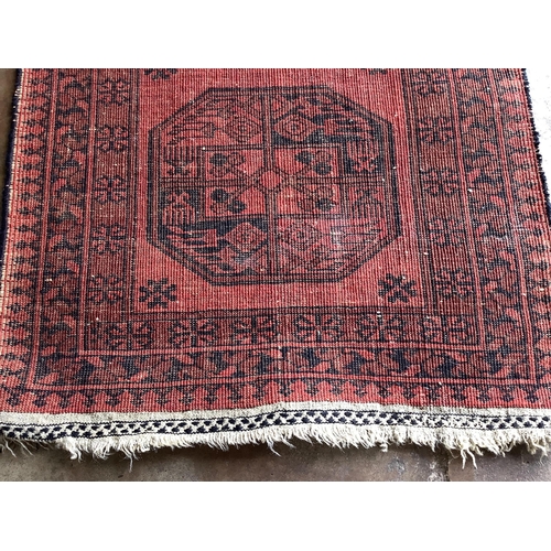 1186 - A pair of Afghan red ground rugs, each 144 x 75cm. Condition - fair