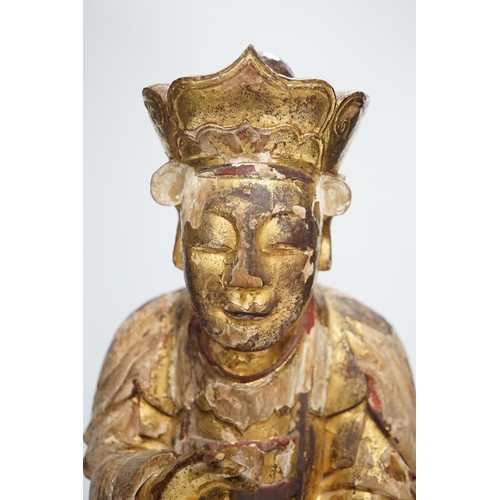 1282 - A Chinese gilt lacquered wooden figure of Buddha, possibly Yuan to Ming, 42cm high. Condition - poor... 