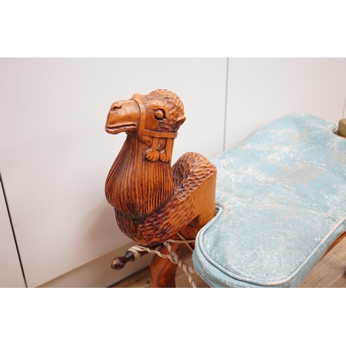 1287 - A carved wood foot stool in the form of a camel, blue stamped patterned leather cushion, 56cm high, ... 