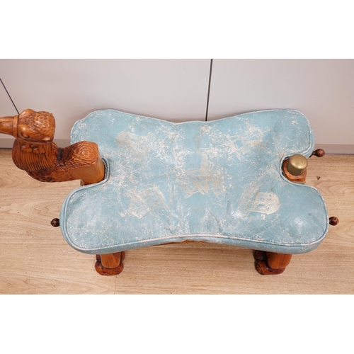 1287 - A carved wood foot stool in the form of a camel, blue stamped patterned leather cushion, 56cm high, ... 