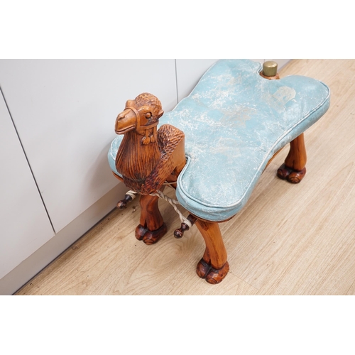 1287 - A carved wood foot stool in the form of a camel, blue stamped patterned leather cushion, 56cm high, ... 