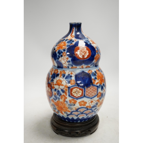 1304 - A Japanese Imari double gourd flask on stand, 23cm high. Condition - gilding worn otherwise good... 