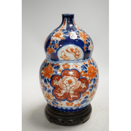 1304 - A Japanese Imari double gourd flask on stand, 23cm high. Condition - gilding worn otherwise good... 