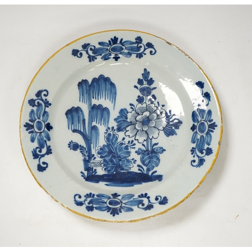 1351 - An 18th century delft blue and white dish, painted with a stylised peony and willow tree, 32cm diame... 