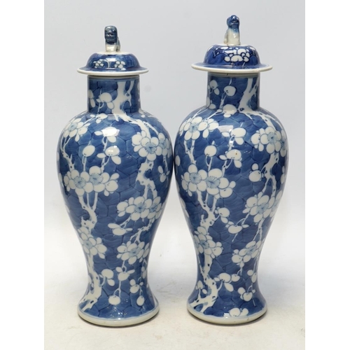 1440 - A pair of Chinese blue and white prunus baluster vases and covers, 31cm high. Condition - one vase g... 