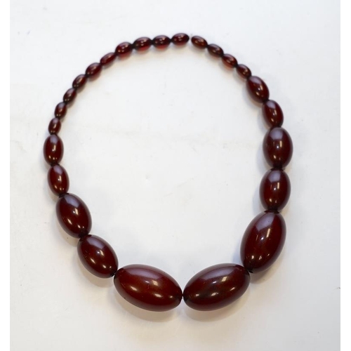 1952 - A single strand graduated simulated cherry amber bead necklace, 38cm, gross weight 65 grams. Conditi... 