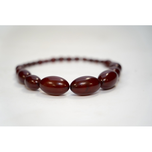 1952 - A single strand graduated simulated cherry amber bead necklace, 38cm, gross weight 65 grams. Conditi... 