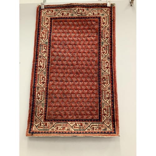 11 - A pair of North West Persian brick red ground rugs, each 124 x 79cm. Condition - fair