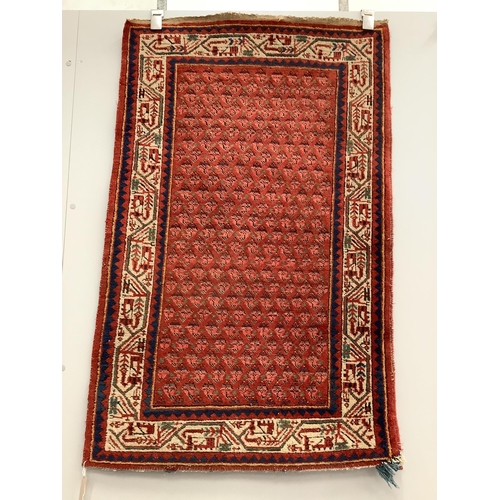 11 - A pair of North West Persian brick red ground rugs, each 124 x 79cm. Condition - fair