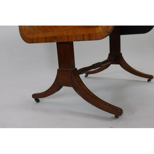 142 - A Regency satinwood banded mahogany sofa table, with two frieze drawers on end standards with turned... 