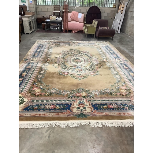 29 - A large Chinese washed woollen gold ground floral embossed carpet, 560cm x 370cm.  Condition - good... 