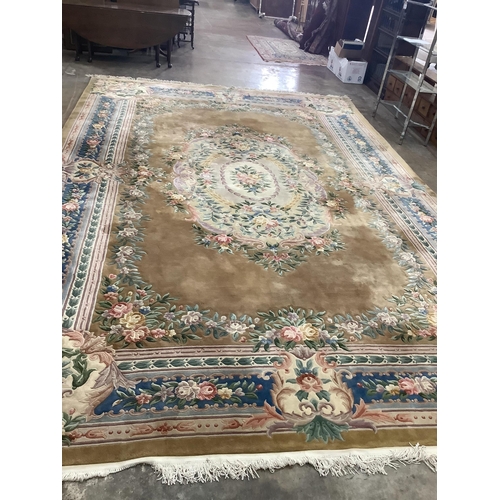 29 - A large Chinese washed woollen gold ground floral embossed carpet, 560cm x 370cm.  Condition - good... 