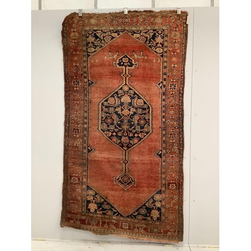 31 - A North West Persian brick red ground rug, 230 x 126cm. Condition - poor