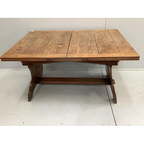 41 - An oak draw leaf dining table, the shaped end standards united by flat stretcher, width 130cm, depth... 