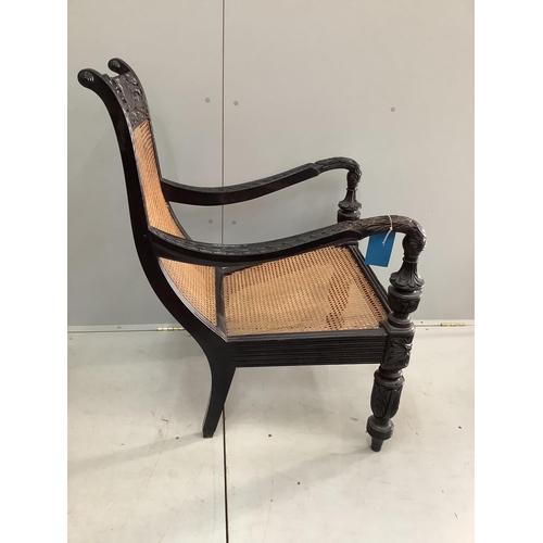 85 - A 19th century Anglo-Indian carved ebony library armchair, with a caned seat and back, width 60cm, d... 