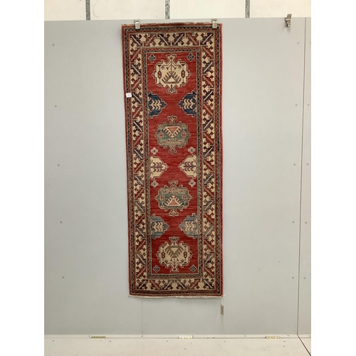 90 - A Caucasian style brick red ground rug, 200 x 72cm. Condition - good