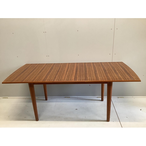 1023 - A mid century Gordon Russell teak dining suite comprising rectangular extending table, twelve chairs... 