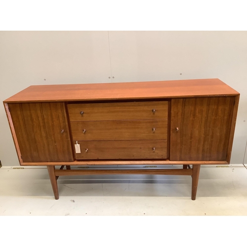 1023 - A mid century Gordon Russell teak dining suite comprising rectangular extending table, twelve chairs... 