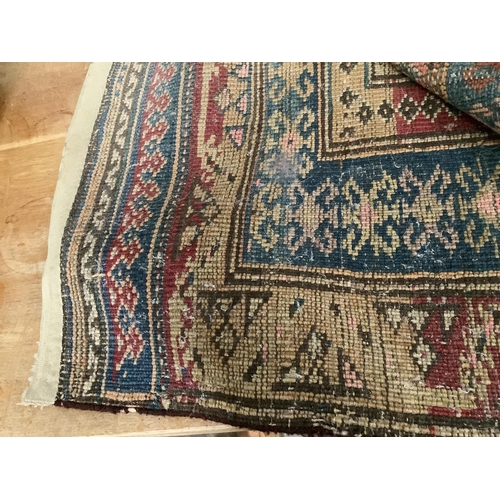 1070 - A Caucasian blue ground rug with flower motifs, 180 x 130cm. Condition - fair