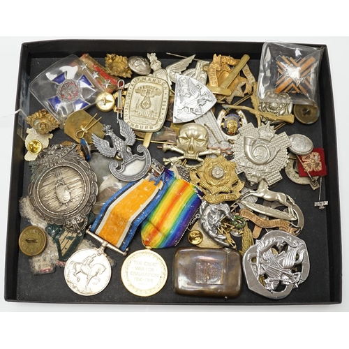 1382 - A collection of military cap badges and medals, including a First World War medal pair awarded to A.... 