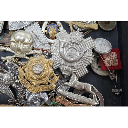 1382 - A collection of military cap badges and medals, including a First World War medal pair awarded to A.... 