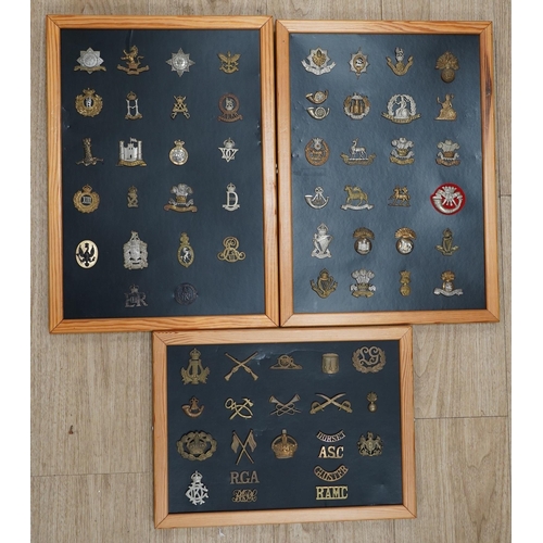 1385 - A collection of fifty-eight military cap badges, plus a few shoulder titles, mounted on four boards ... 