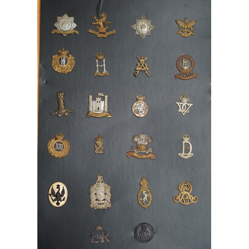 1385 - A collection of fifty-eight military cap badges, plus a few shoulder titles, mounted on four boards ... 