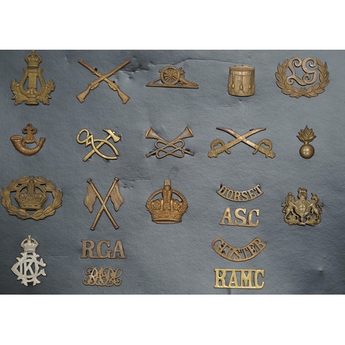 1385 - A collection of fifty-eight military cap badges, plus a few shoulder titles, mounted on four boards ... 