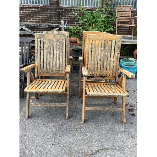 1014 - A set of four stained teak folding garden armchairs. Condition - poor