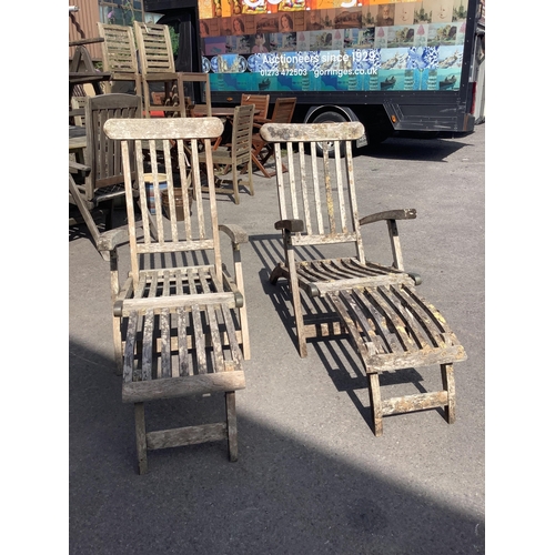 1017 - A pair of weathered teak steamer garden chairs, width 59cm, height 98cm. Condition - fair