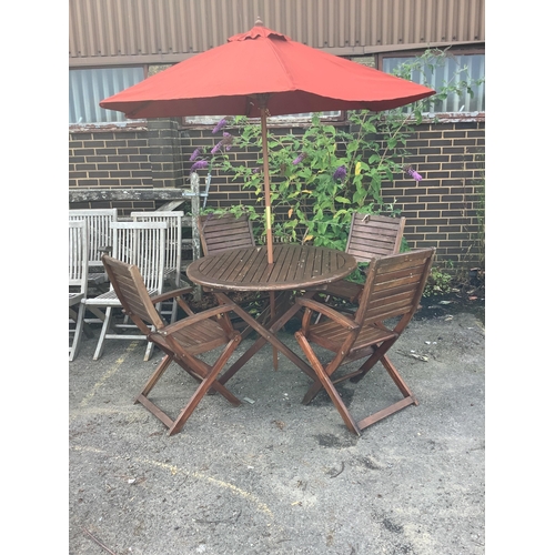 1018 - A stained teak circular folding garden table, diameter 106cm, height 75cm together with four folding... 