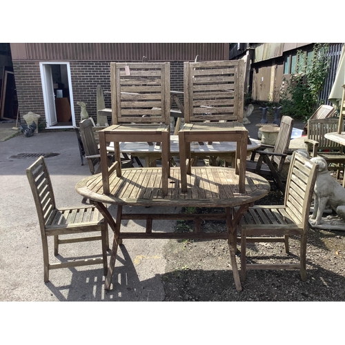 1023 - A weathered teak folding garden table, width 150cm, depth 90cm, height 71cm and four chairs. Conditi... 