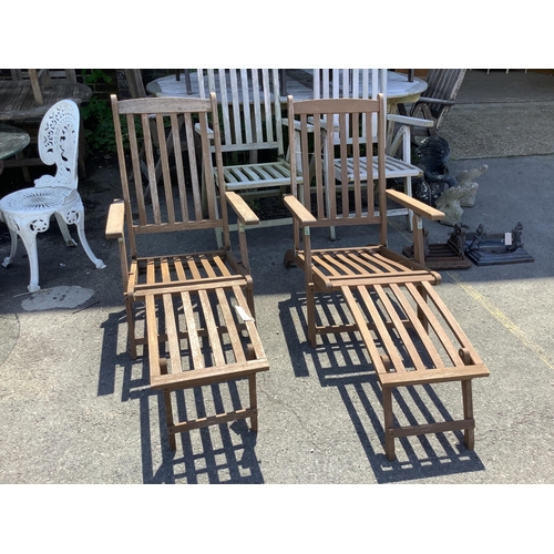 1025 - A pair of stained teak garden steamer chairs, width 59cm, height 97cm. Condition - fair