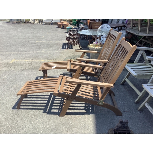 1025 - A pair of stained teak garden steamer chairs, width 59cm, height 97cm. Condition - fair