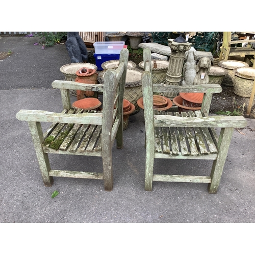 1039 - A pair of weathered teak garden armchairs, width 63cm, depth 64cm, height 94cm. Condition - fair... 