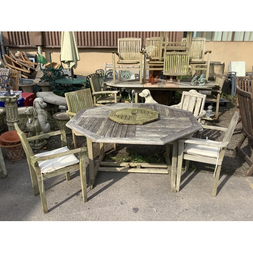 1040 - A weathered teak octagonal garden table with lazy Susan width 150cm, height 75cm, and a harlequin se... 