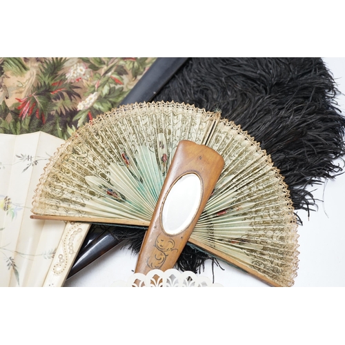 464 - A black ostrich feather and tortoiseshell fan and four others including a carved bone and floral pai... 