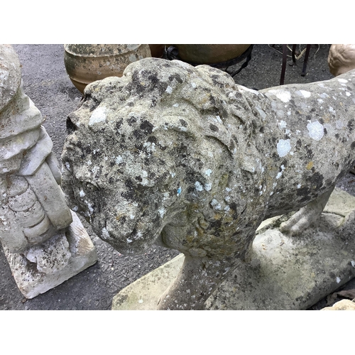 125 - A pair of reconstituted stone standing lion garden ornaments, length 66cm, height 56cm. Condition - ... 