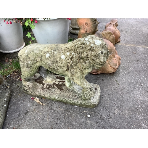 125 - A pair of reconstituted stone standing lion garden ornaments, length 66cm, height 56cm. Condition - ... 