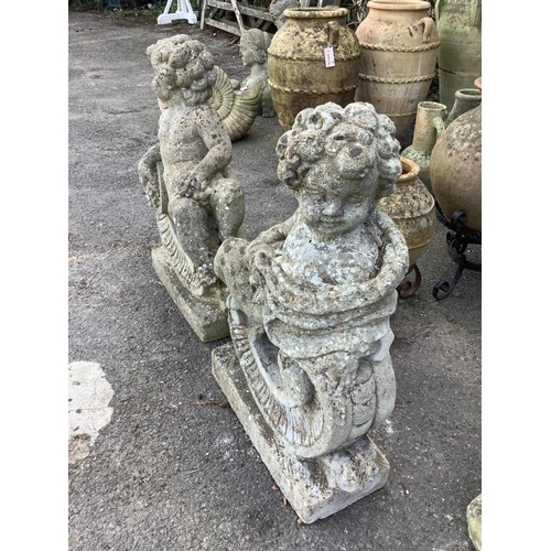 129 - A pair of reconstituted stone putti and scroll garden ornaments, height 68cm. Condition - poor to fa... 