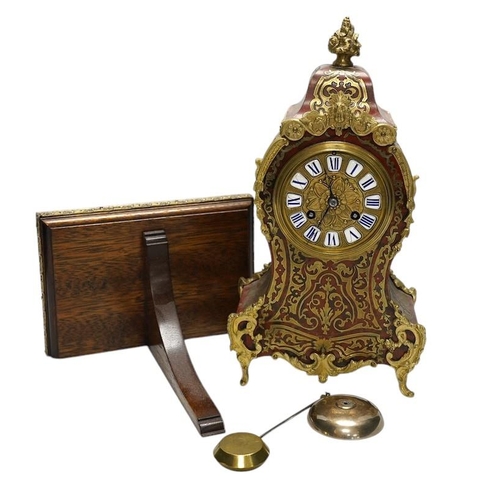 257 - A Louis XV style red boulle eight day mantel clock, with bracket and pendulum, clock 30cm high. Cond... 