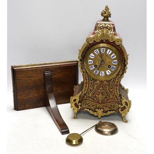 257 - A Louis XV style red boulle eight day mantel clock, with bracket and pendulum, clock 30cm high. Cond... 