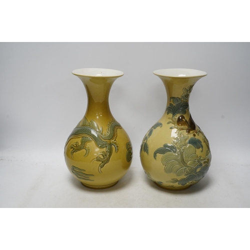 267 - Two Lladro vases decorated in relief with dragons and birds, 26cm high. Condition - good