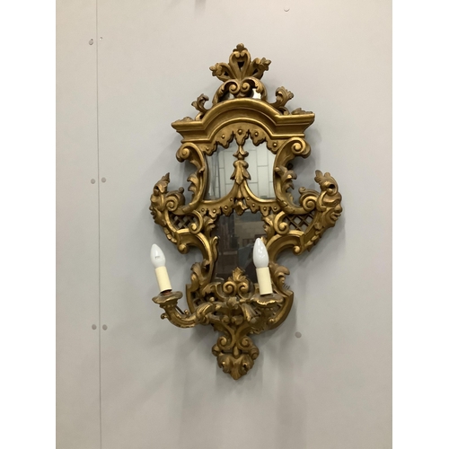 29 - A pair of Italian style carved giltwood and composition two branch girandoles, width 52cm, height 86... 