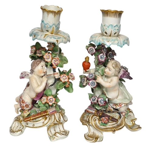 346 - A pair of 19th century Derby porcelain candlesticks, with winged cupid stems, 22cm. Condition - po... 