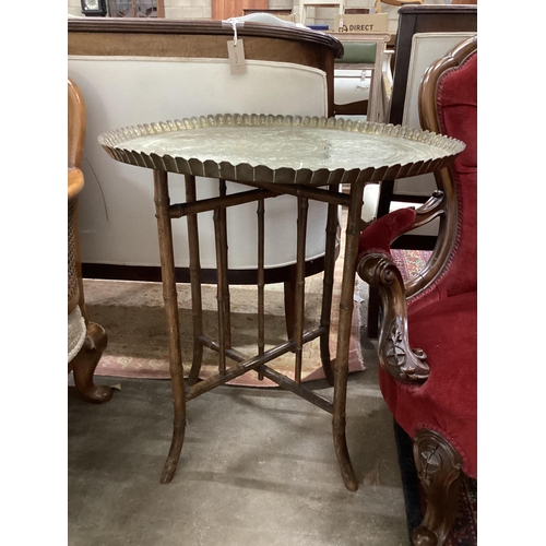 44 - An early 20th century circular engraved brass tray top table on folding bamboo stand, diameter 64cm,... 