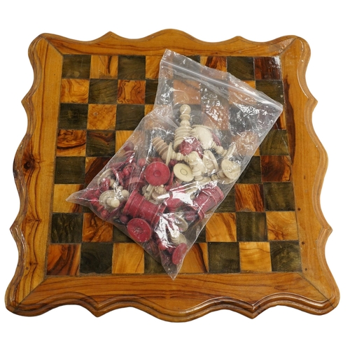 516 - A 19th century stained and natural bone chess set with board, 34cm x 34cm. Condition - fair, some da... 