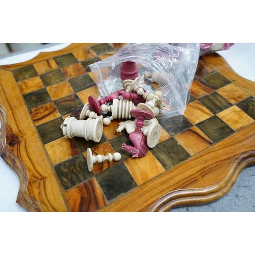 516 - A 19th century stained and natural bone chess set with board, 34cm x 34cm. Condition - fair, some da... 