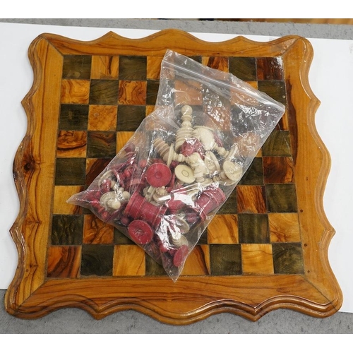 516 - A 19th century stained and natural bone chess set with board, 34cm x 34cm. Condition - fair, some da... 